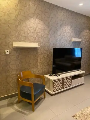 a living room with a tv and a chair at Luxury one bedroom in DAMAC in Amman