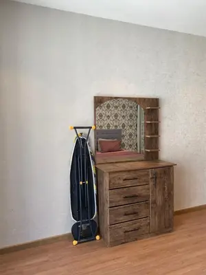 a suitcase on a wooden dresser next to a mirror at Luxury one bedroom in DAMAC in Amman