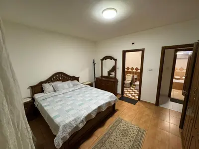 a bedroom with a bed and a dresser and a mirror at Comfort Apartment in Amman