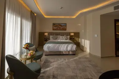 a bedroom with a bed and two chairs and a table at Petra Legacy Luxury in Petra