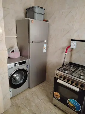 a kitchen with a stove and a refrigerator and a washing machine at العقبه in Aqaba