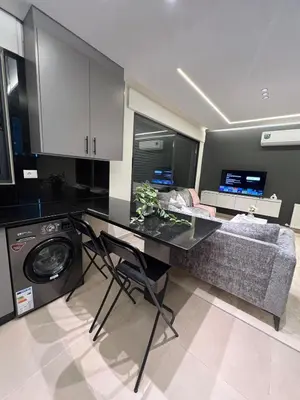 a kitchen with a washing machine and a couch at Amman Central Comfort in Amman