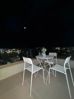 a white table and chairs on a balcony with a view at Amman Central Comfort in Amman