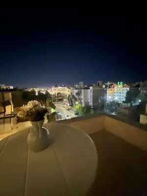 a vase of flowers sitting on a table on a balcony at Amman Central Comfort in Amman
