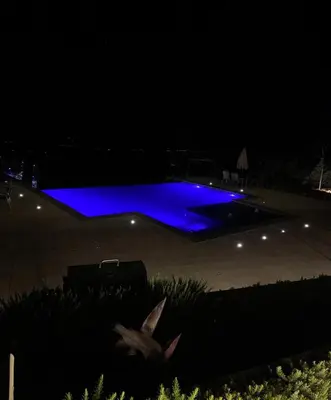 a swimming pool with blue lighting at night at sofia Farm in Al Salt