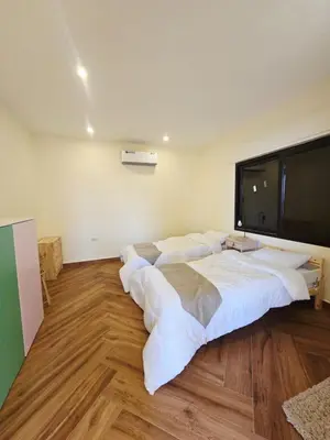 a room with a large bed with white sheets at sofia Farm in Al Salt