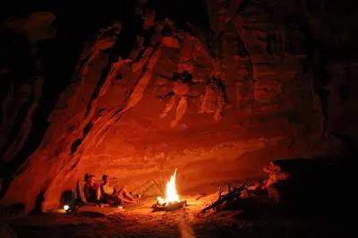 two people sitting around a fire in a cave at cave under the stars in Wadi Rum