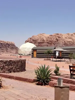 a building in the middle of a desert with a tent at مخيم علاء in Wadi Rum