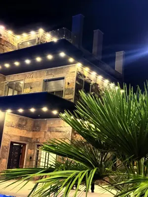 a building with lights on top of it at night at Taj Villa 2 - entire Villa in Deadsea front beach in Sowayma