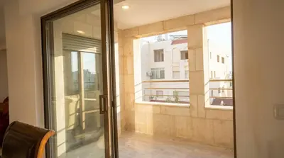 a sliding glass door with a view of a building at Cozy & Spacious 3 En-Suite Bedroom Apartment in Amman