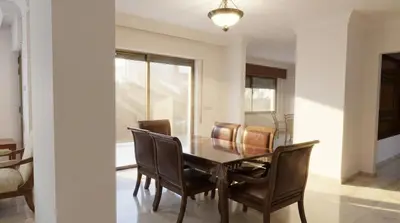 a dining room with a wooden table and chairs at Cozy & Spacious 3 En-Suite Bedroom Apartment in Amman