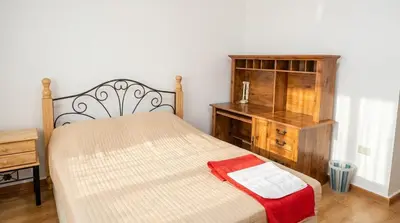 a bedroom with a bed and a wooden dresser at Cozy & Spacious 3 En-Suite Bedroom Apartment in Amman