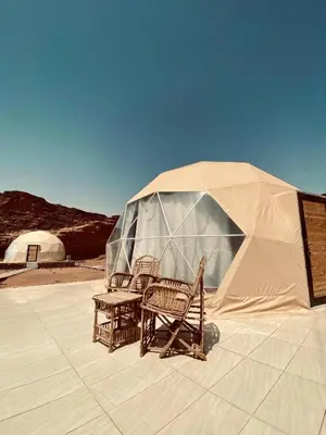 two wicker chairs and a tent in the desert at Desert yanal wadi rum in Disah