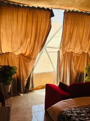 a bedroom with a large window with curtains at Desert yanal wadi rum in Disah