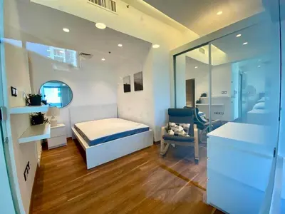 a bedroom with a bed and a chair in it at Sunny Duplex for rent in Abdali in Amman