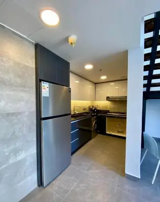 a large kitchen with a stainless steel refrigerator at Sunny Duplex for rent in Abdali in Amman