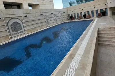 a large swimming pool in the middle of a building at Sunny Duplex for rent in Abdali in Amman