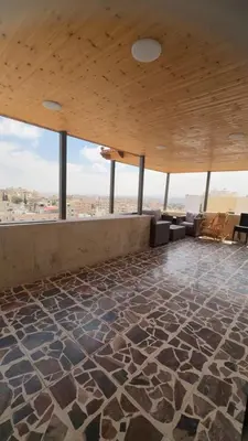 a room with a stone floor and a wooden ceiling at شقق-روف للايجار اليومي والاسبوعي in Al Qarţū‘īyah