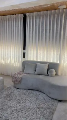 a couch sitting in front of a large window at شقق-روف للايجار اليومي والاسبوعي in Al Qarţū‘īyah