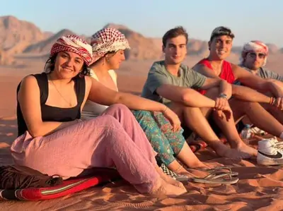 a group of people sitting on the beach at Mountain Stars Camp in Wadi Rum