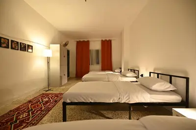 a room with four beds in a room at AL Majd hostel in Amman