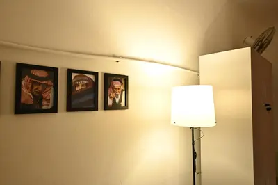 a group of pictures on a wall with a lamp at AL Majd hostel in Amman