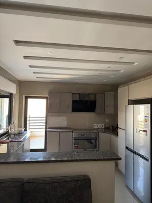 a kitchen with a refrigerator and a counter top at 3 Bedrooms Flat in Rabwat Abdoun in Amman