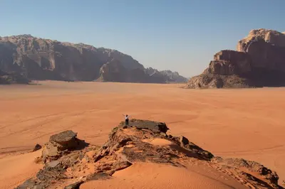a person standing on a rock in the desert at Nayef camp wadi Rum in Wadi Rum