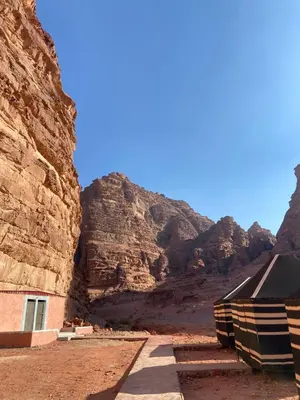 a building in a canyon with a mountain at Nayef camp wadi Rum in Wadi Rum