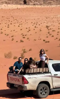 a group of people sitting in the back of a truck at Wadi Rum Bubbles Luxury Camp in Wadi Rum