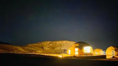 a group of domes in the desert at night at Aurora Luxury Wadi Rum in Wadi Rum
