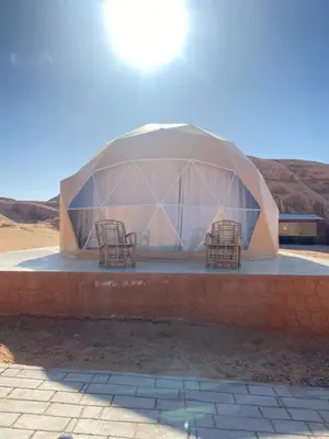 a dome shaped building with two chairs in it at Aurora Luxury Wadi Rum in Wadi Rum