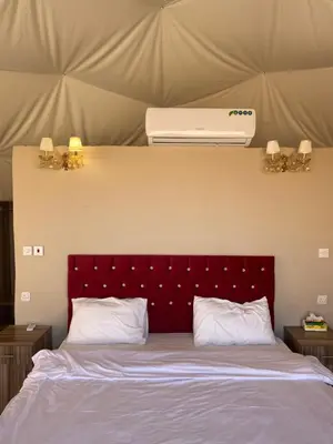 a bedroom with a bed with a air conditioner above it at Aurora Luxury Wadi Rum in Wadi Rum