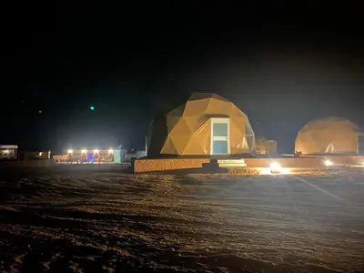 two domed buildings in a field at night at Aurora Luxury Wadi Rum in Wadi Rum