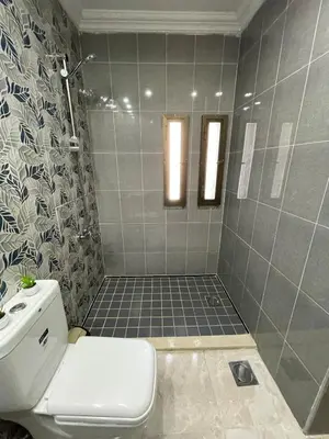 a bathroom with a toilet and a tiled shower at Apartment in Jabal Amman, very beautiful, new in Amman