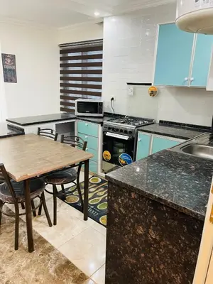 a kitchen with blue cabinets and a wooden table at Apartment in Jabal Amman, very beautiful, new in Amman