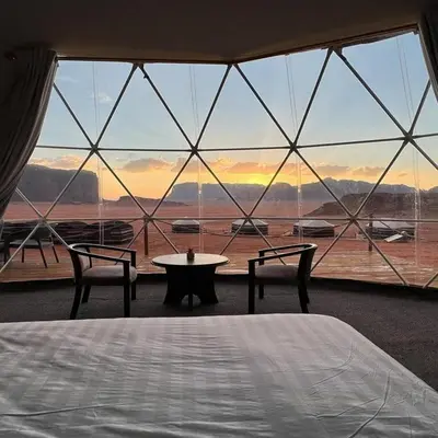 a bedroom with a bed and a large glass window at Super Delxue Tent in Azraq ash Shīshān