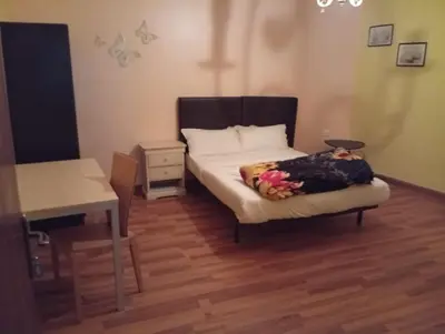 a bedroom with a bed with a table and a desk at Monastery in Wadi Musa