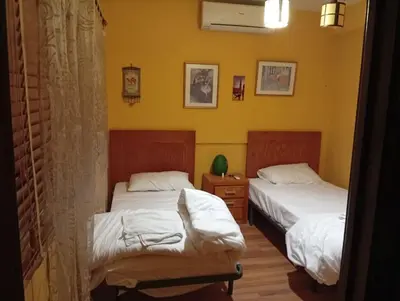 two beds in a room with yellow walls at Monastery in Wadi Musa