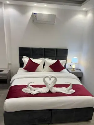 two white swans are sitting on a bed at The charming view in Wadi Musa