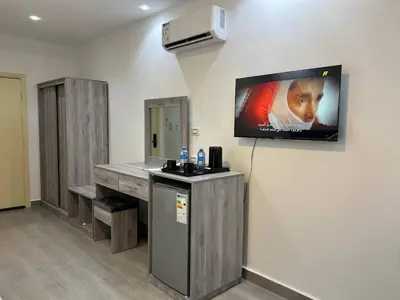 a room with a television on a wall with a counter at The charming view in Wadi Musa