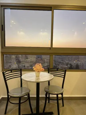 a table and two chairs in front of a large window at The charming view in Wadi Musa