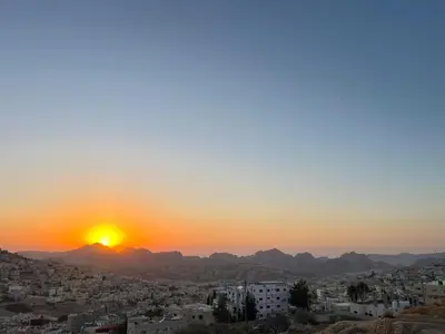 a view of the sun setting over a city at The charming view in Wadi Musa