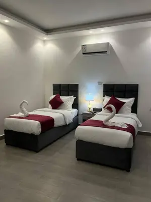 a bedroom with two beds with red and white pillows at The charming view in Wadi Musa