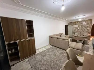 a living room with two couches and a entertainment center at 2BR Apartment in Tlaa Al Ali, Parking, AC, WIFI in Amman