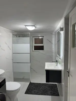a white bathroom with a toilet and a sink at Two-Bedroom Apartment in Swefieh in Amman