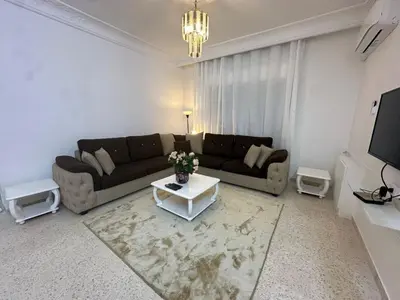 a living room with a couch and a table at Two-Bedroom Apartment in Swefieh in Amman
