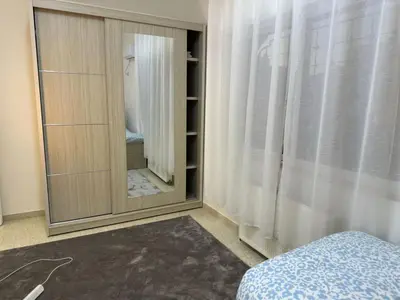 a bedroom with a mirror and a bed in a room at Two-Bedroom Apartment in Swefieh in Amman