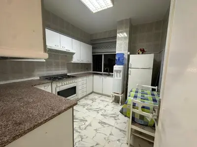 a kitchen with white cabinets and a white refrigerator at Two-Bedroom Apartment in Swefieh in Amman