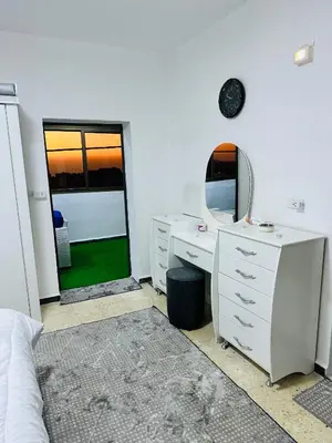 a bedroom with a desk and a mirror and a bed at شقة مفروشة واسعة وهادئة in Umm Juraysāt